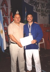 El maestro Juan José "Franco Di Meglio entrega a Jorge Juri la Medalla de Campeón Mundial y el Certificado que así lo acredita.