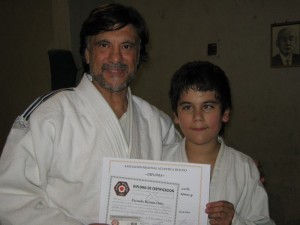 El Prof. Jorge Juri entrega a Facundo Ortiz  su Diploma de Graduación.